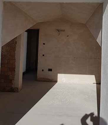 Asunto aurinkorannikolla, jossa rakennusvaiheessa oleva huoneisto alaslasketulla katolla